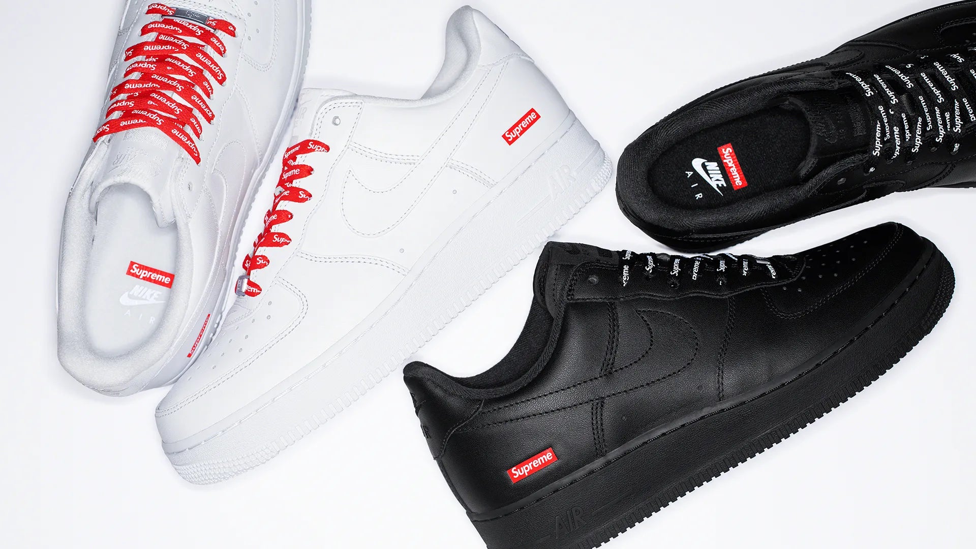Two pairs of Nike Air Force 1 sneakers in black and white with Supreme branding and contrasting laces.