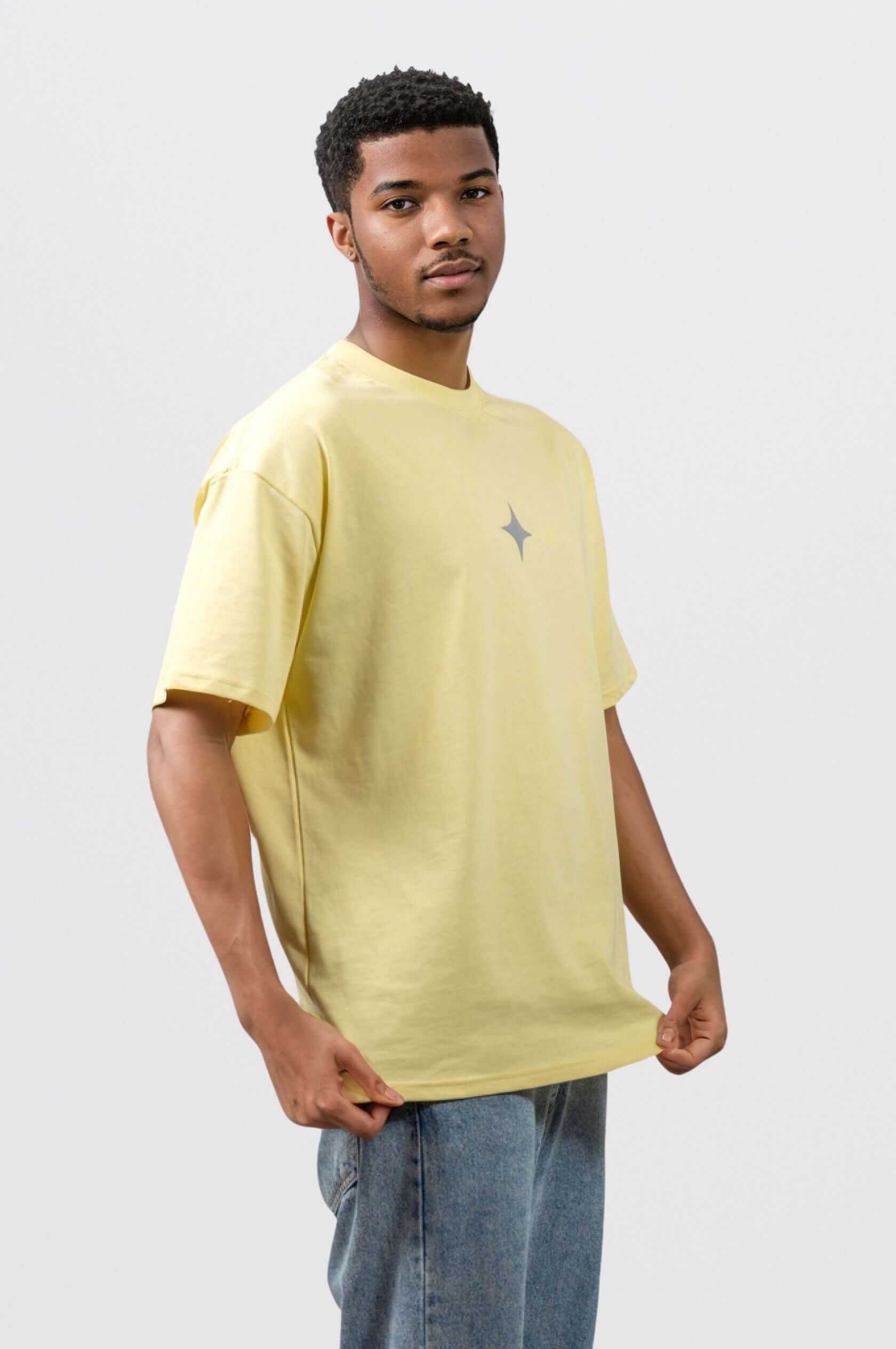 Model wearing a yellow tee with a grey print, showcasing a slightly oversized fit and signature Sanity embroidery.