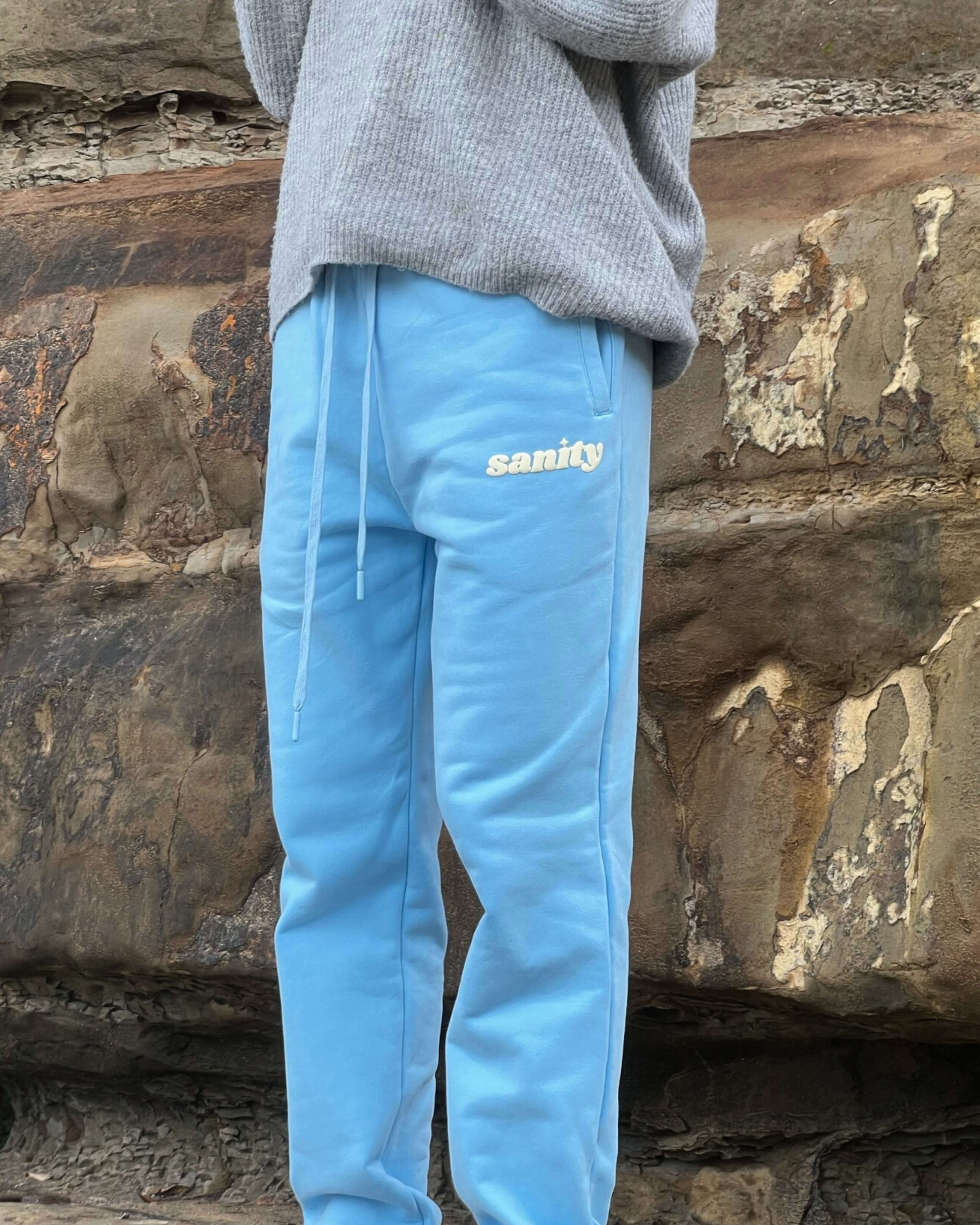 Ice blue trackpants by Sanity, featuring elastic waistband and side pockets, styled with a cozy sweater.