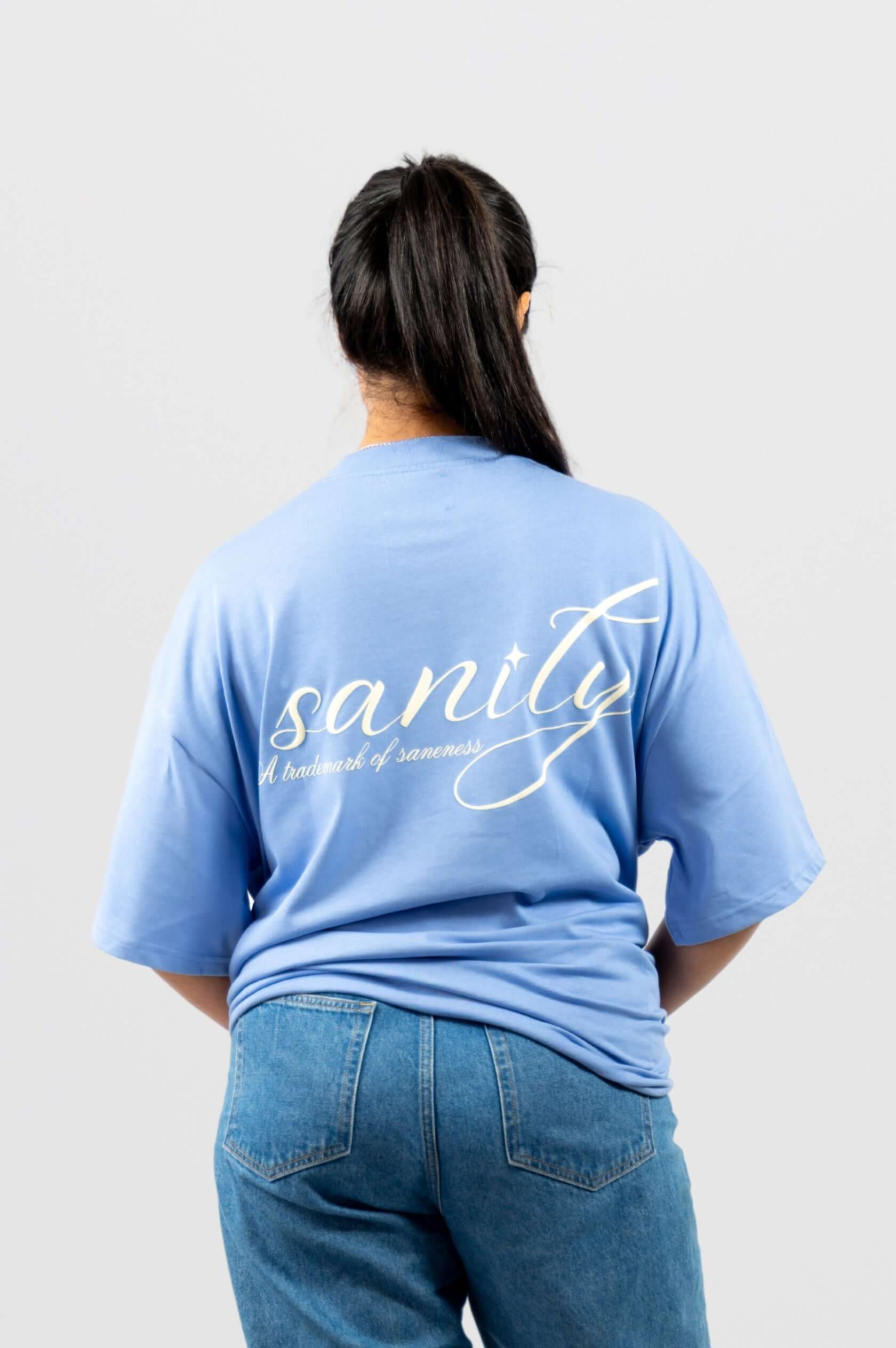 Back view of sky blue Sanity Ocean Tee featuring classic white print and relaxed fit.