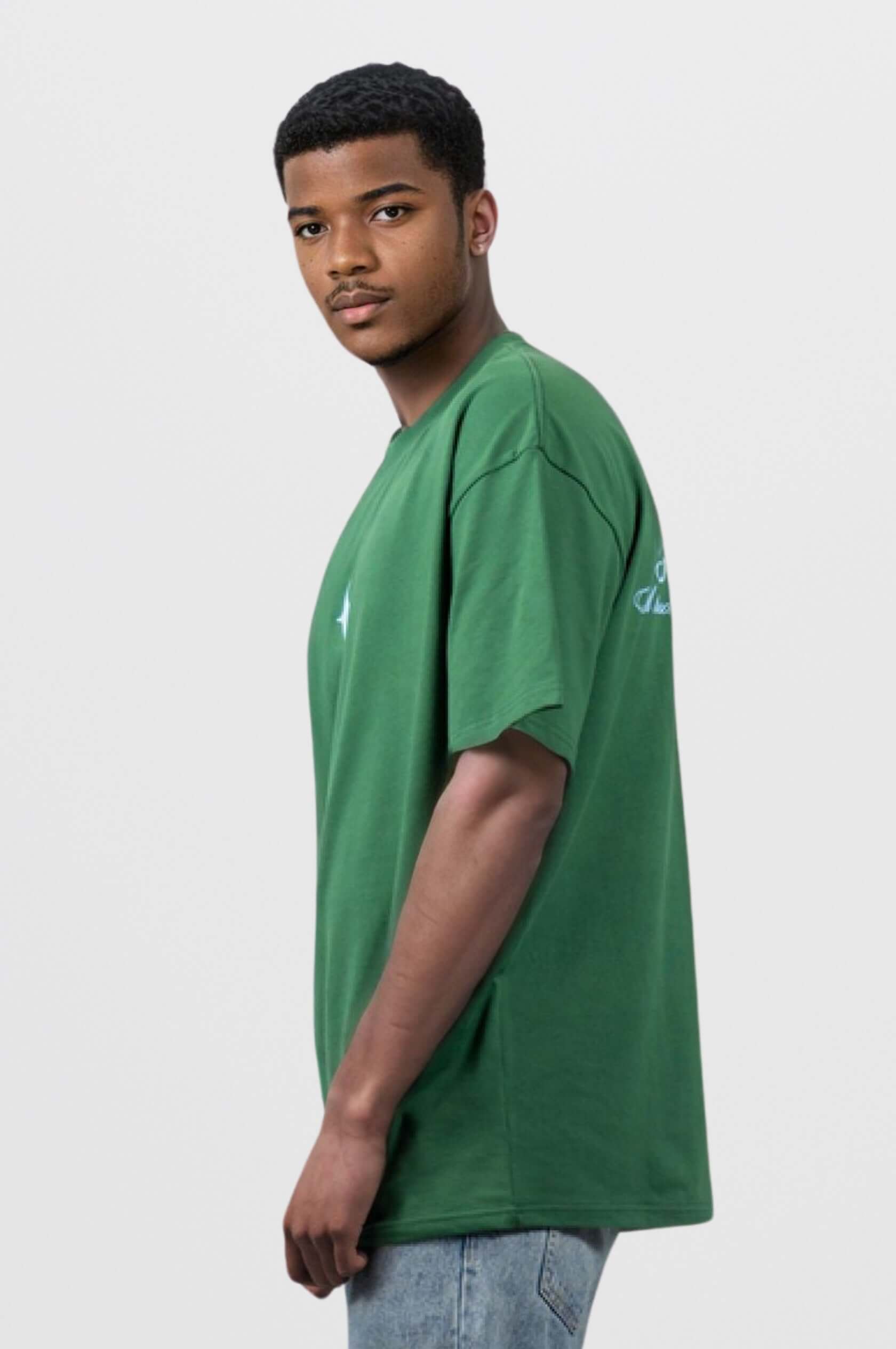 Model wearing a forest green oversized tee with light blue print and sanity embroidery, showcasing a modern and comfortable style.