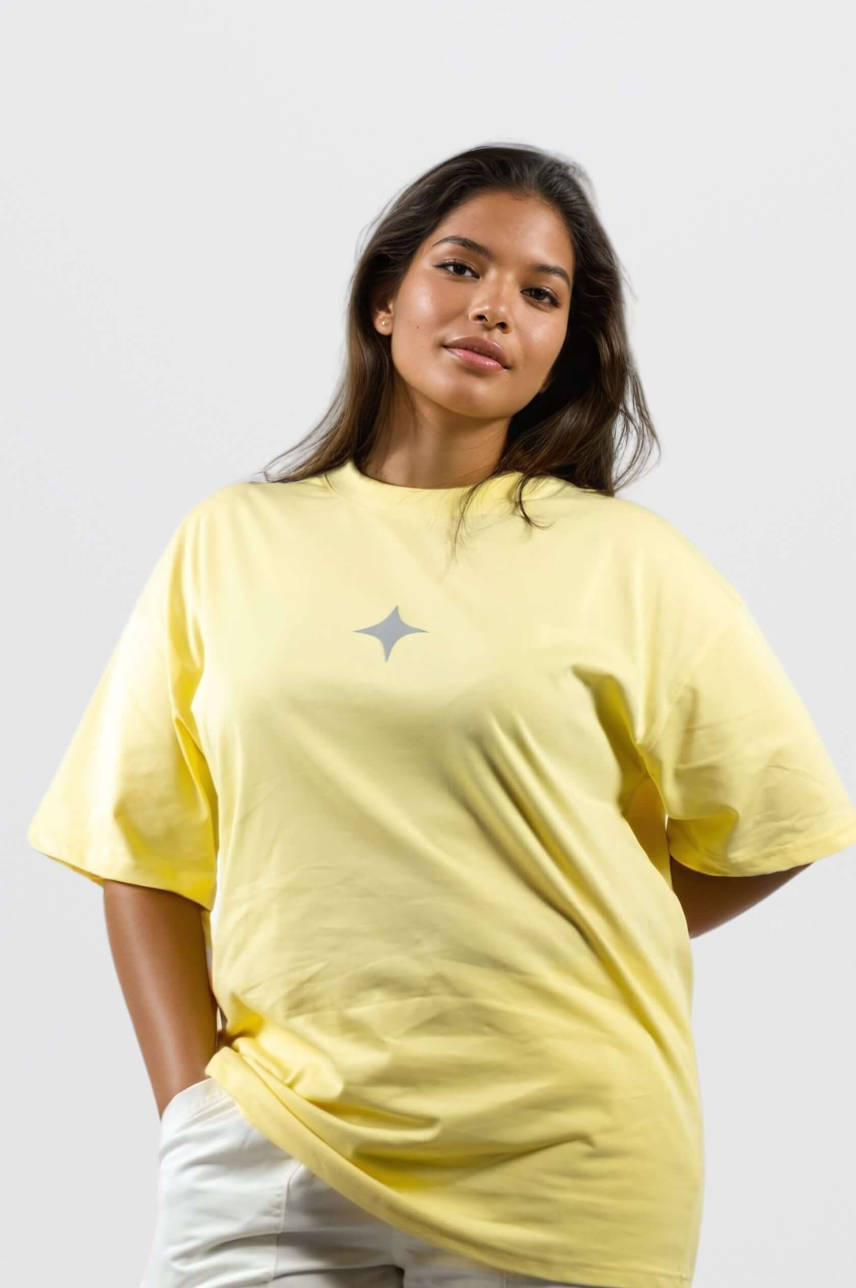 Model wearing a bright yellow oversized tee with a chic grey print, showcasing signature sanity embroidery.