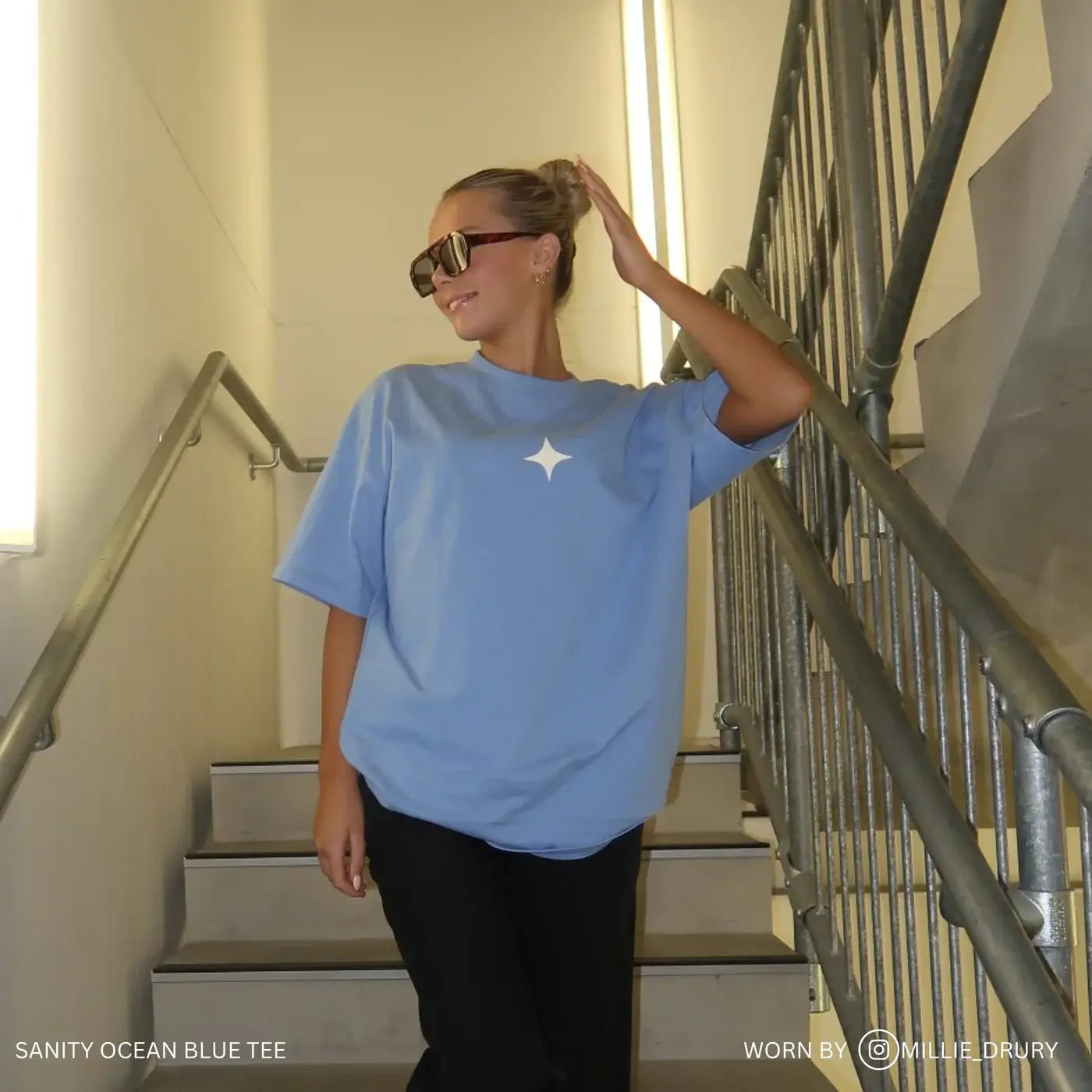 Model wearing Sanity Ocean Tee, a sky blue oversized shirt with white print, exuding casual elegance and comfort.