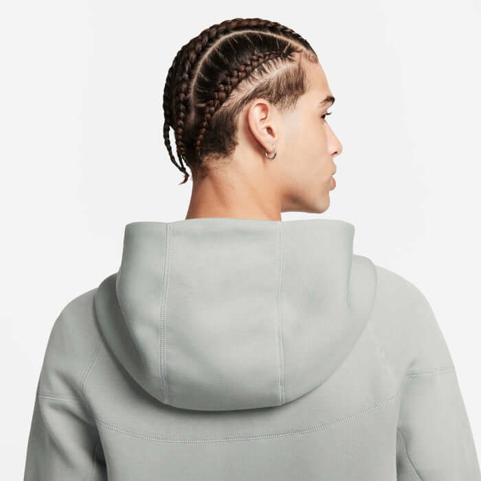 Nike Tech Fleece Windrunner Hoodie in Mica Green, showing back view with braided hairstyle.