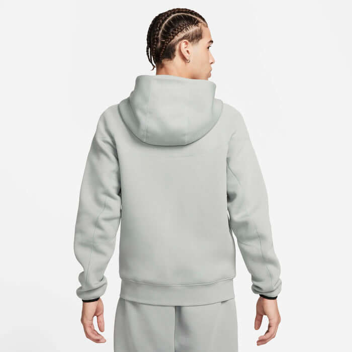 Back view of a man wearing a Nike Tech Fleece Windrunner Hoodie in Mica Green.