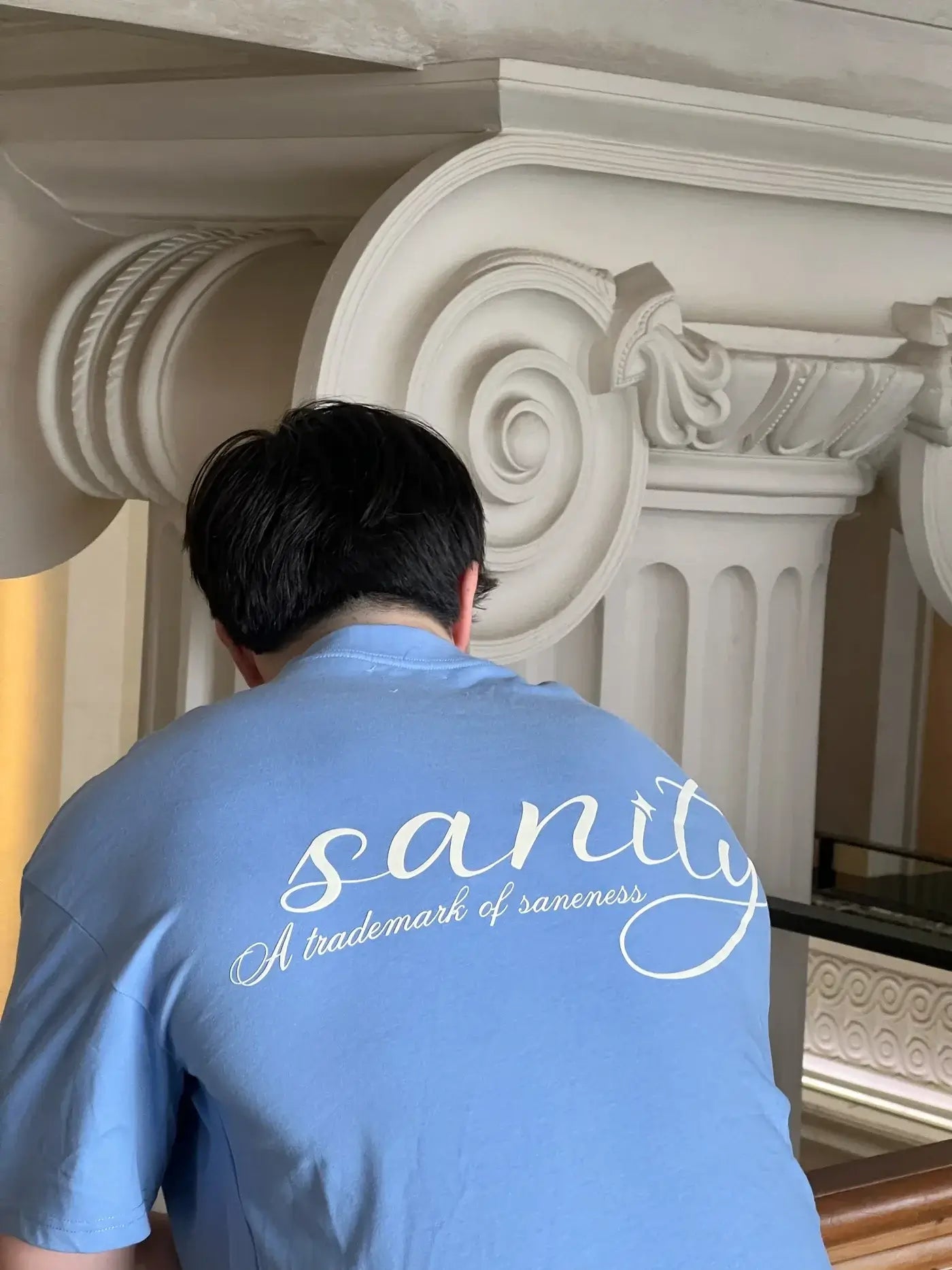 Man wearing a sky blue Sanity Ocean Tee with white print, showcasing relaxed style and premium cotton comfort.