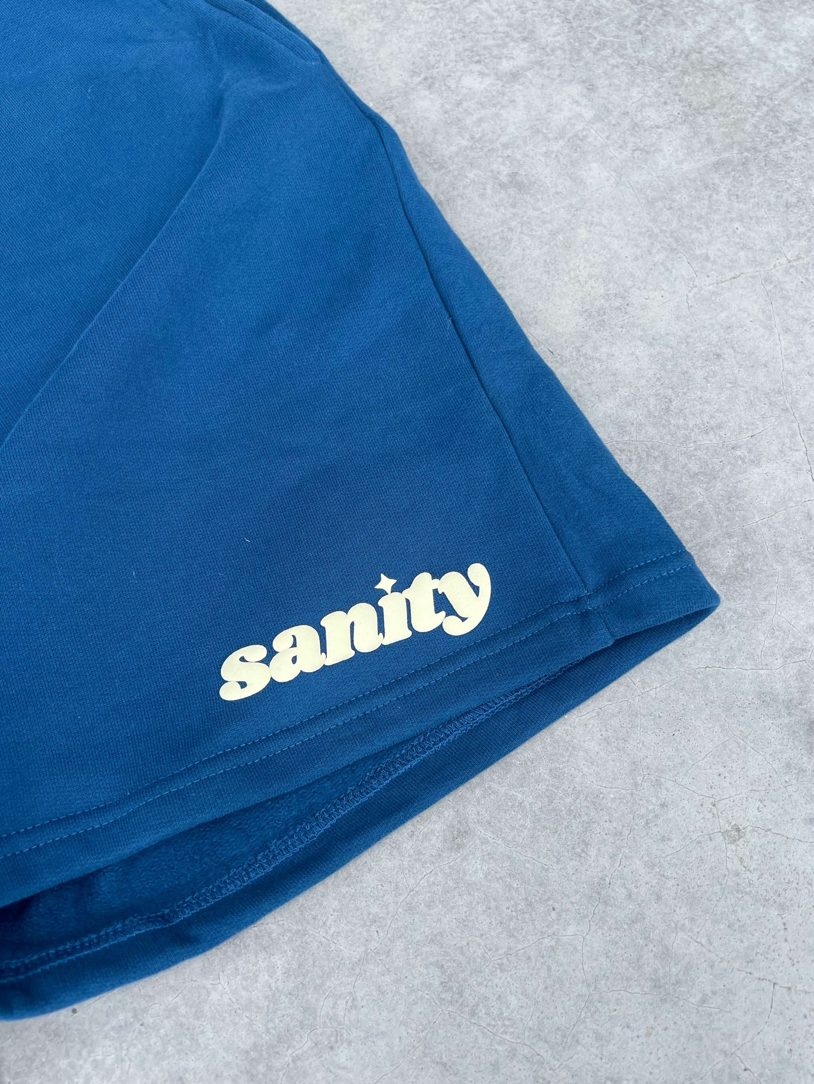 Close-up of Sanity brand deep navy men's shorts showcasing the logo and soft fabric detail.
