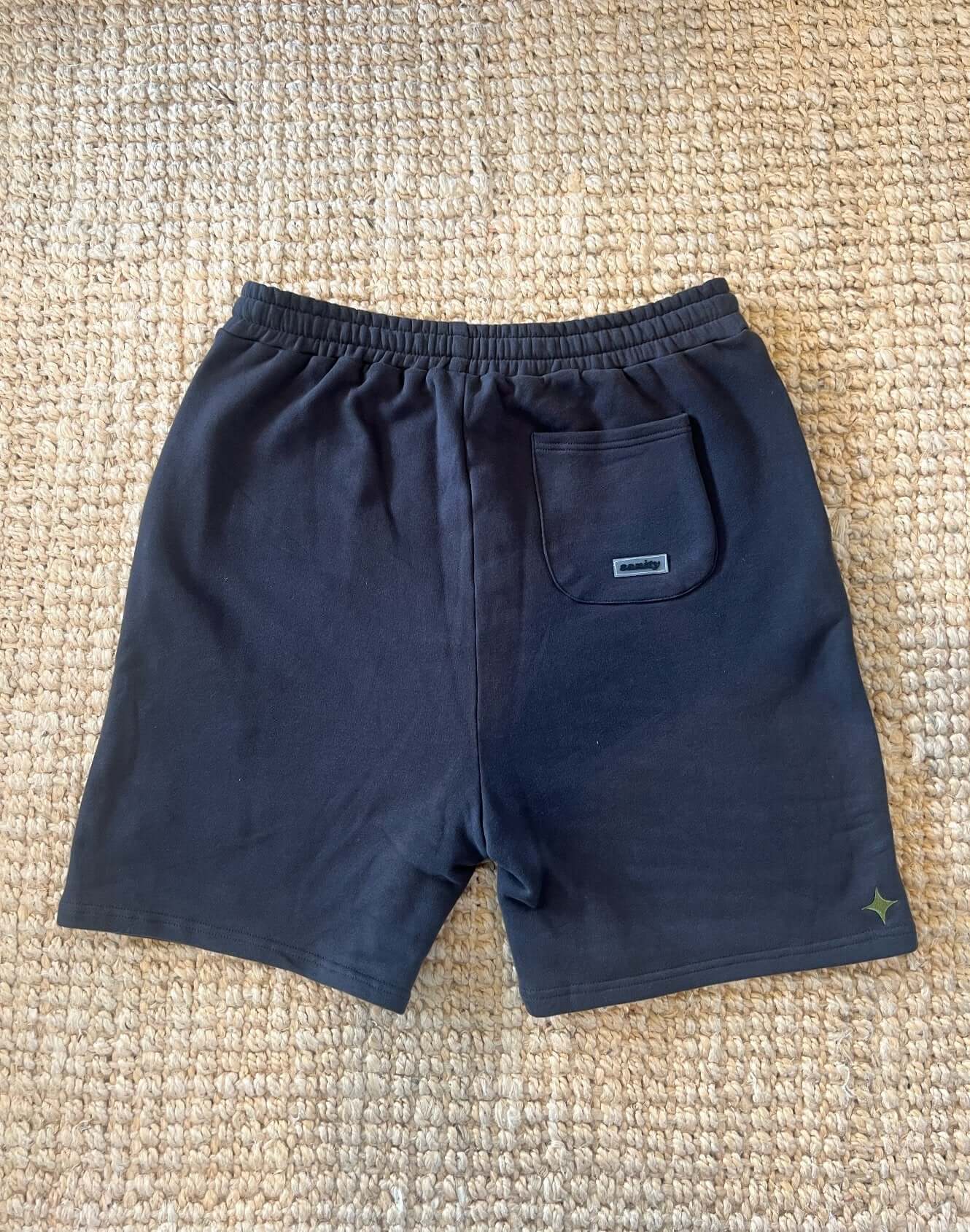 Back view of Sanity Shadow Men's Shorts in deep charcoal, showcasing pocket and drawcord design.