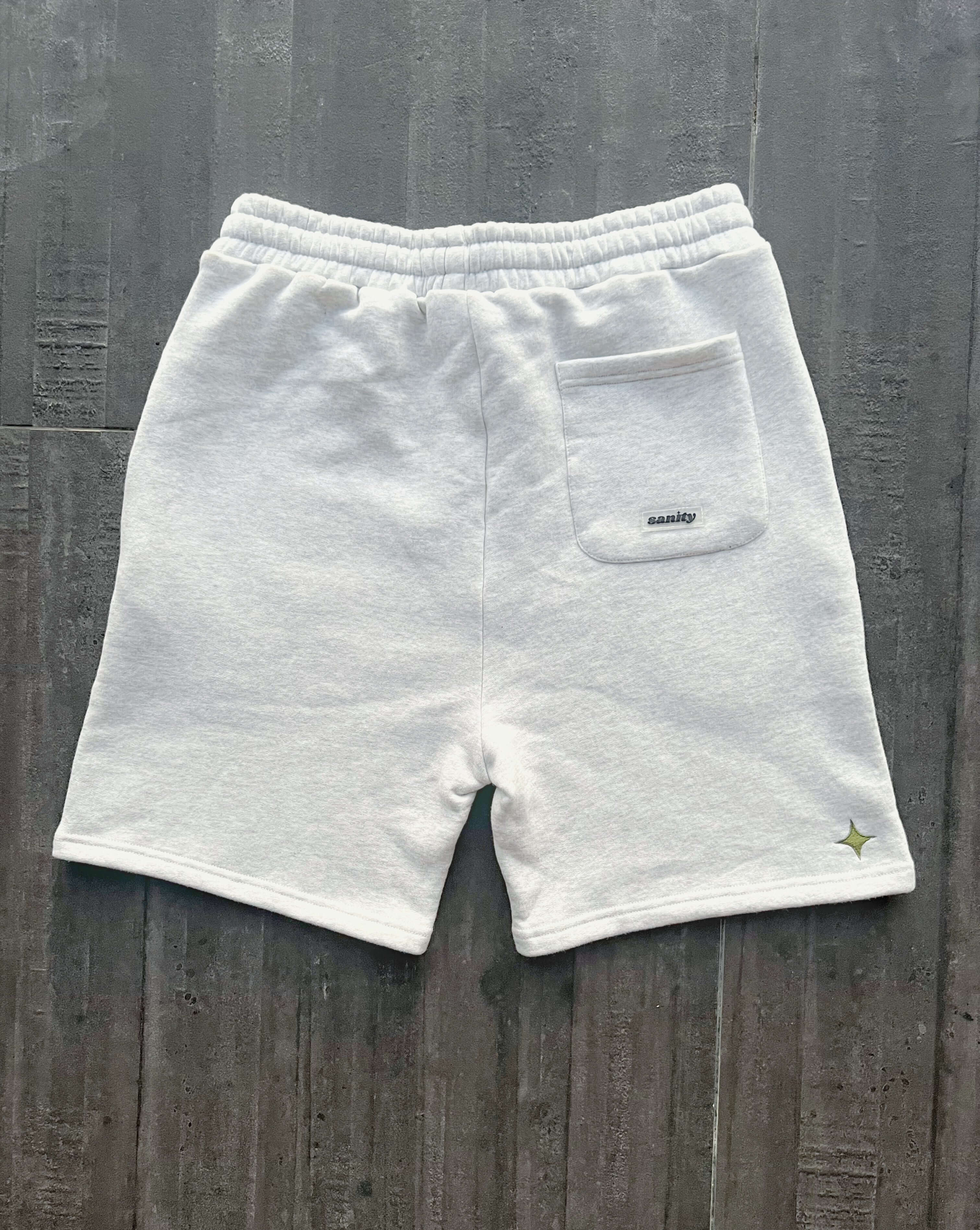 Back view of Sanity Snow Men's Shorts in white cotton, featuring a back pocket and a draw cord for comfort.