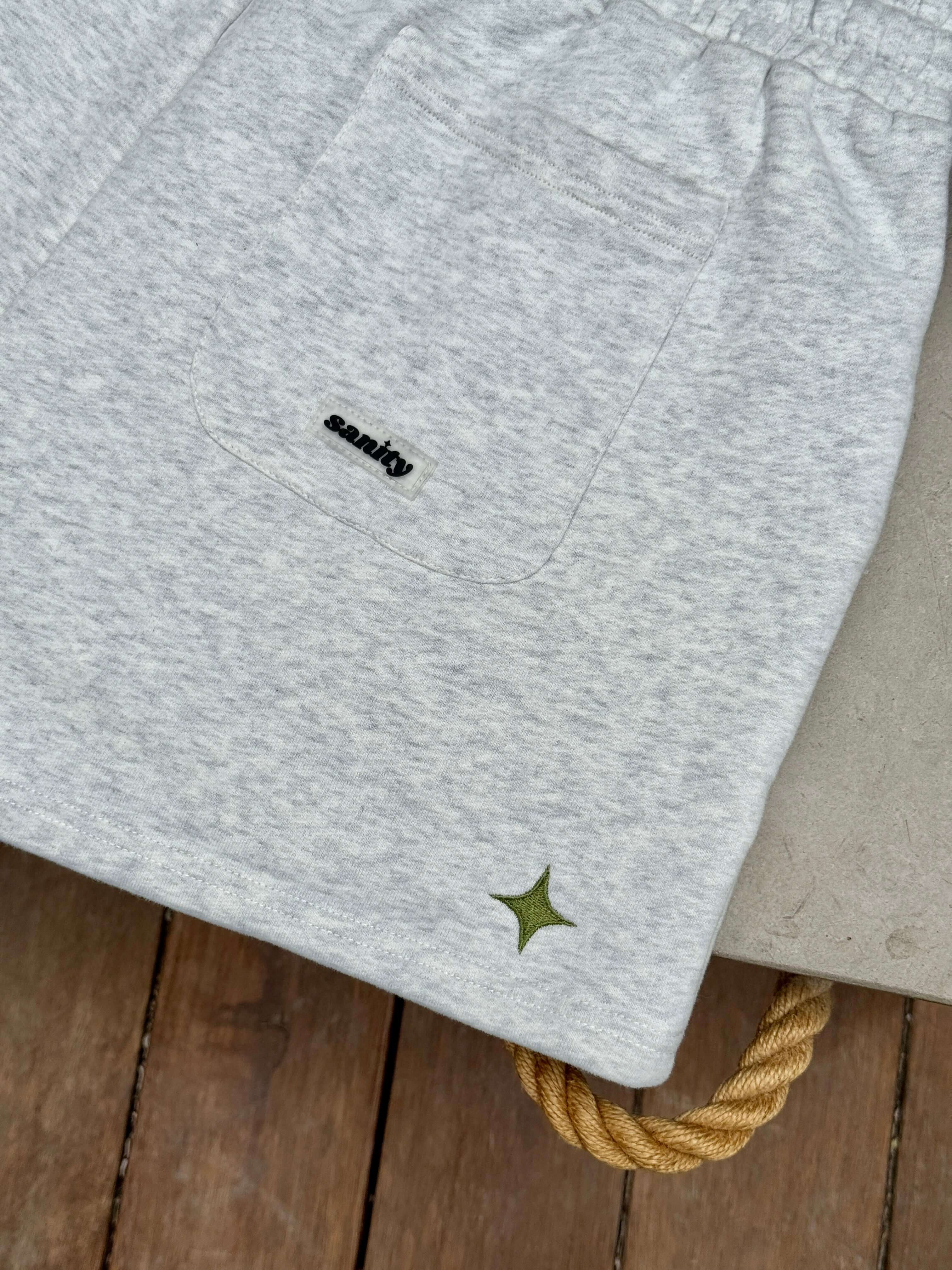 Close-up of Sanity grey women's shorts featuring a back pocket and star detail on the hem.