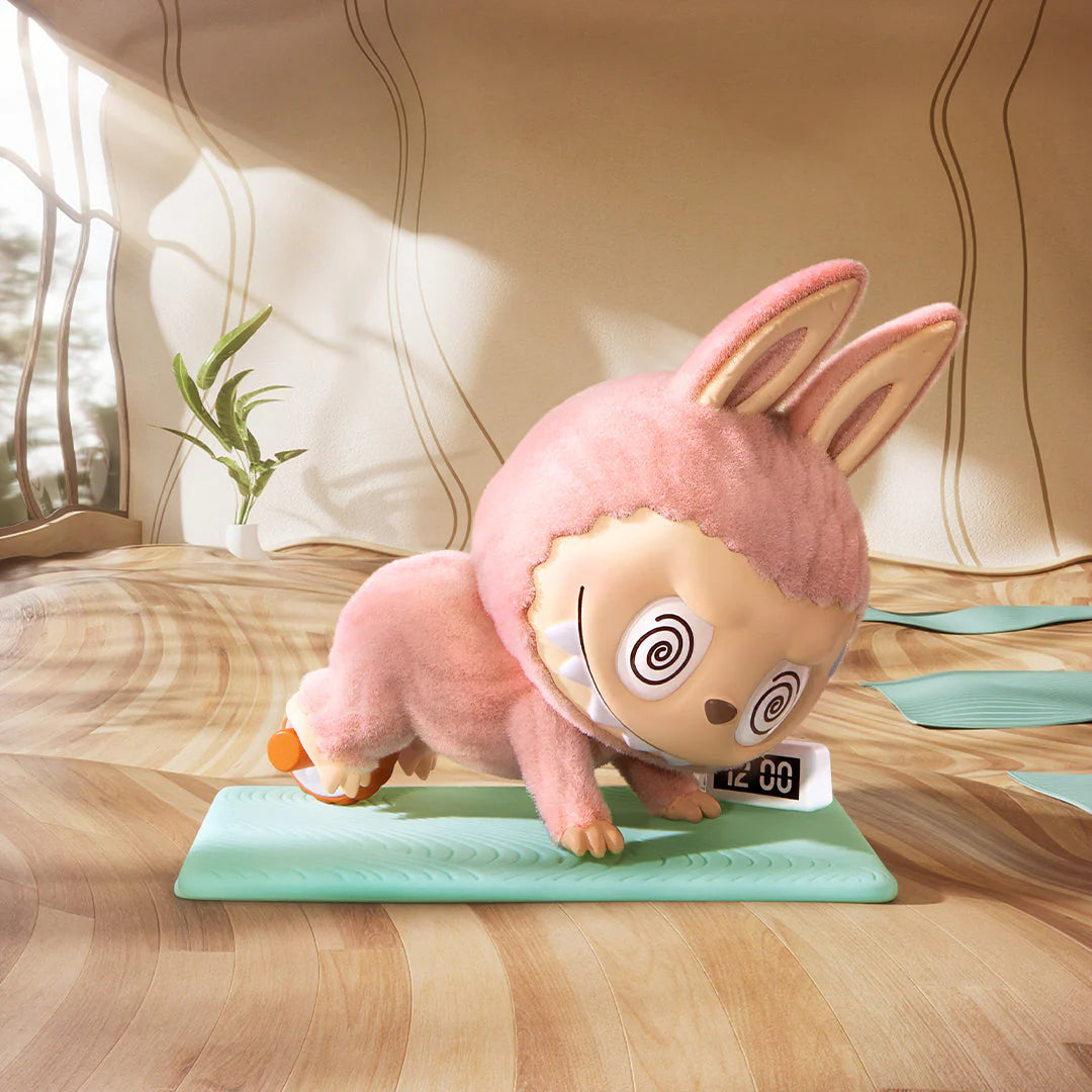 Pop Mart Labubu figure in a pink bunny costume practicing yoga on a mat, showcasing playful design and unique character.