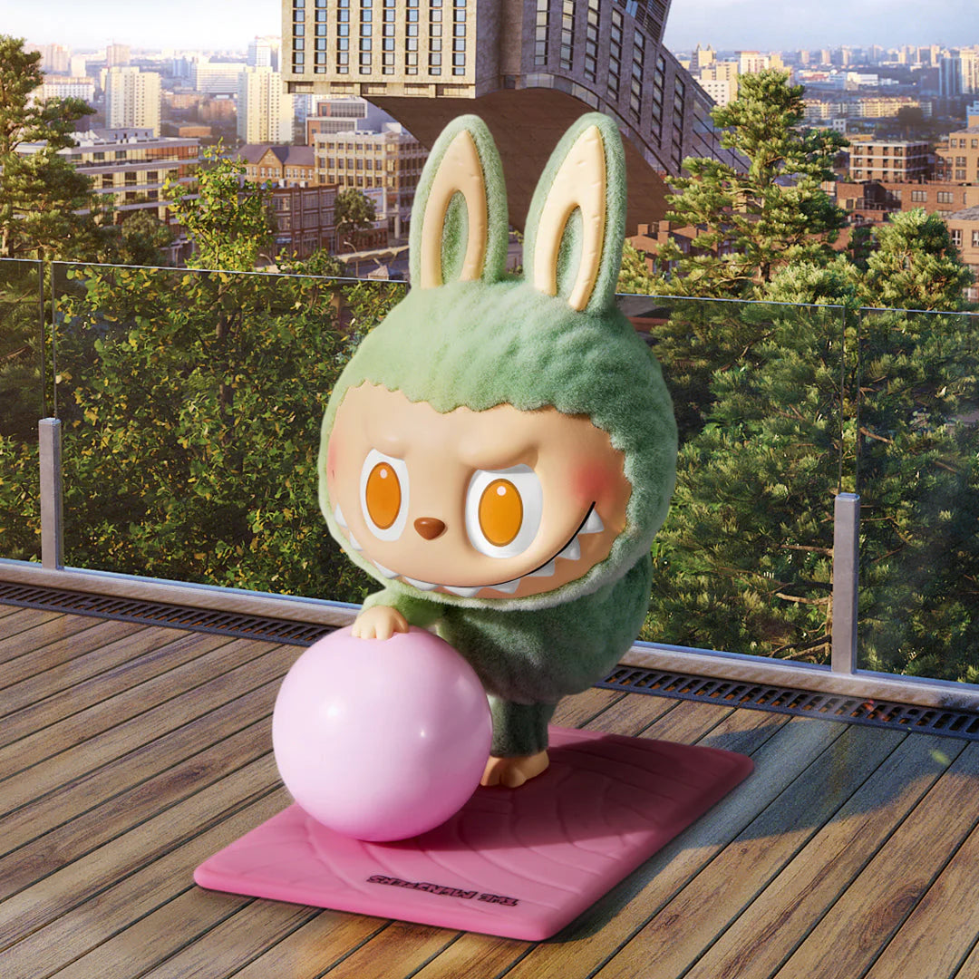 Pop Mart Labubu figure in bunny costume practicing yoga with a pink ball outdoors.