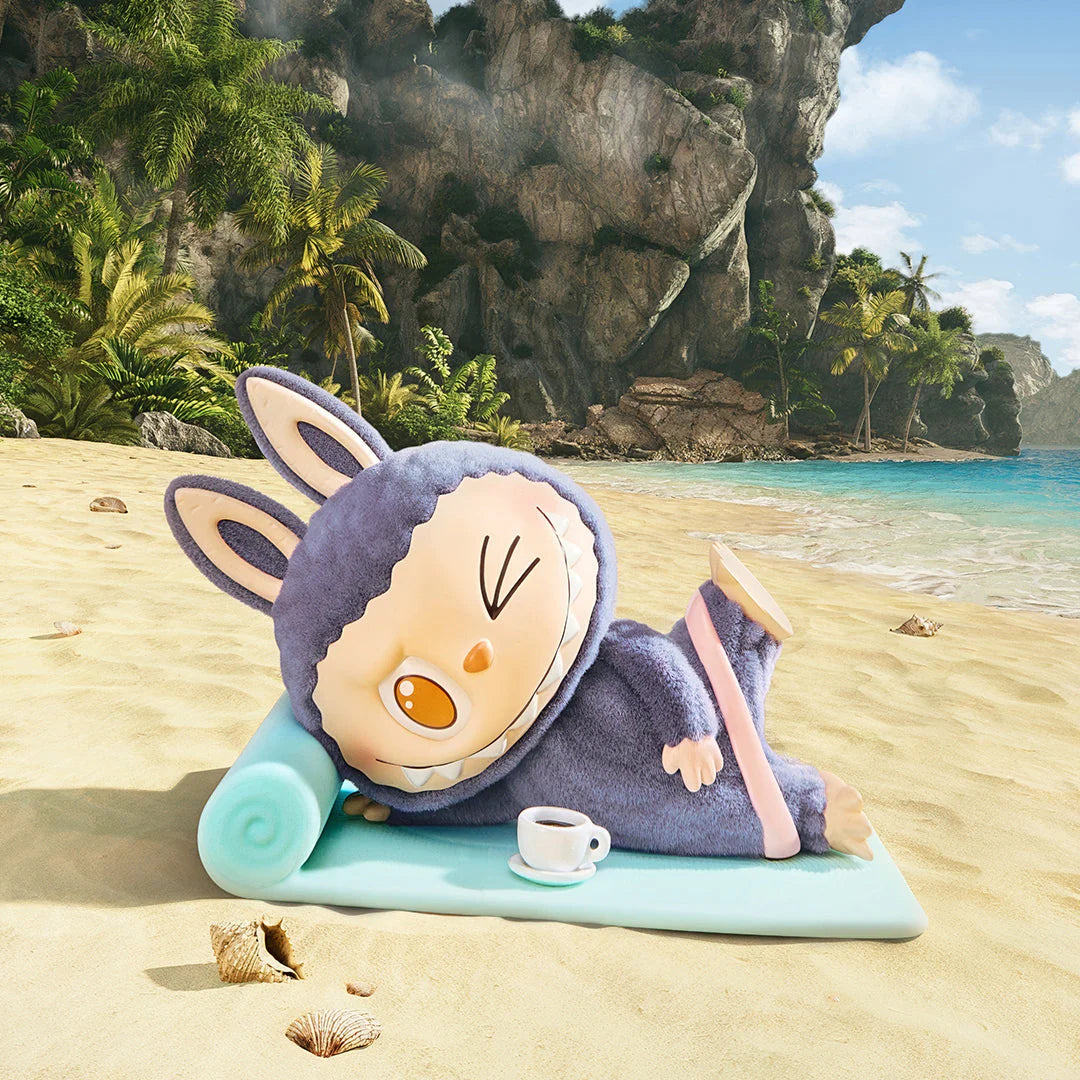 Lazy yoga figure of Labubu on a beach mat with a coffee cup, surrounded by tropical scenery.