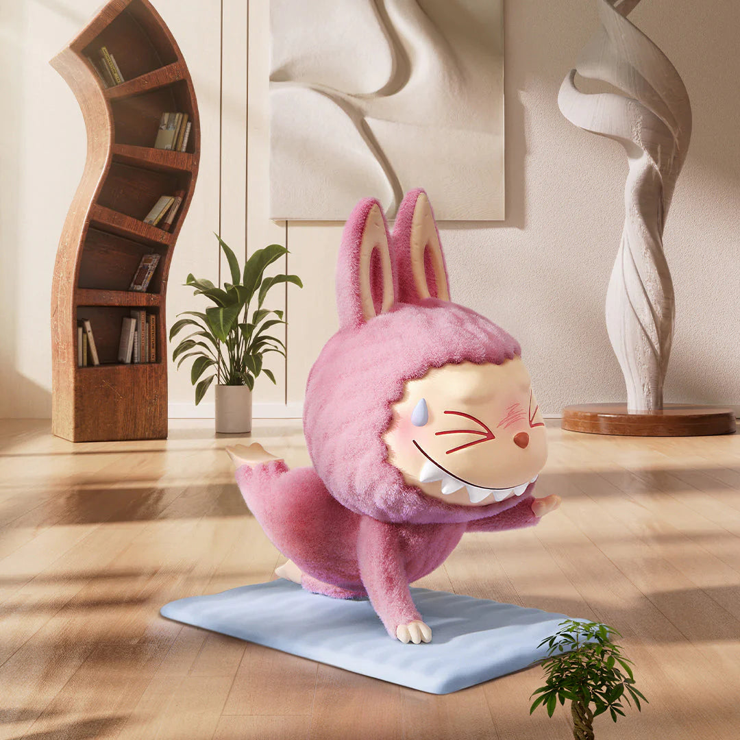 Pop Mart Labubu figure in a pink bunny outfit performing yoga in a cozy indoor setting.