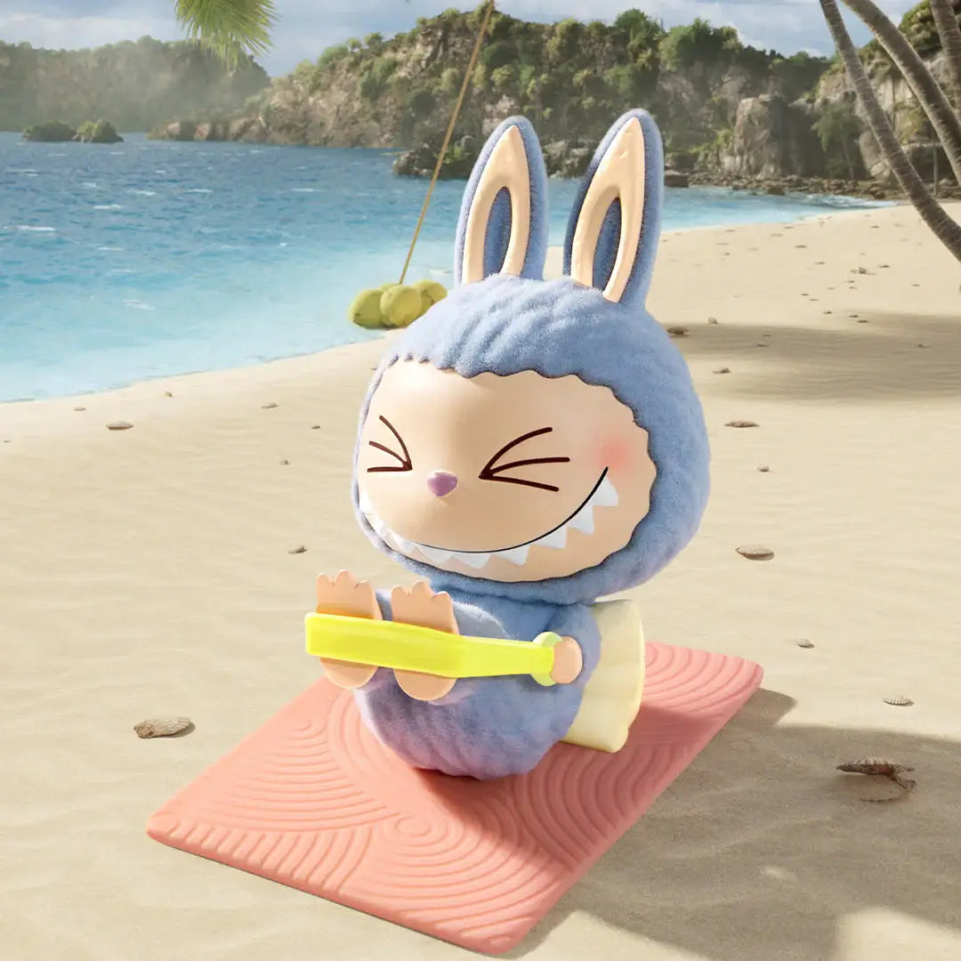 Pop Mart Labubu figure in a blue bunny costume practicing yoga on a beach mat by the ocean.