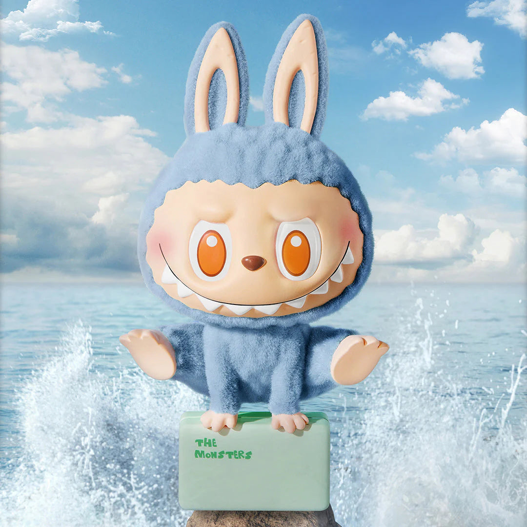 Pop Mart Labubu figure in a blue bunny costume, part of The Monsters Lazy Yoga series, displayed by the water.