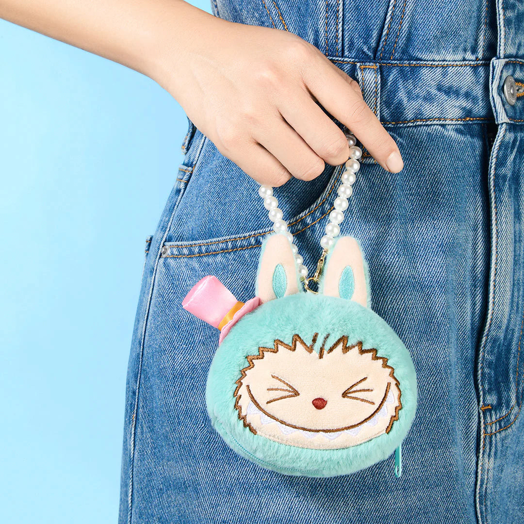 Cute teal plush bag with bunny ears and smiling face, held by a person in denim, perfect for fun outings.