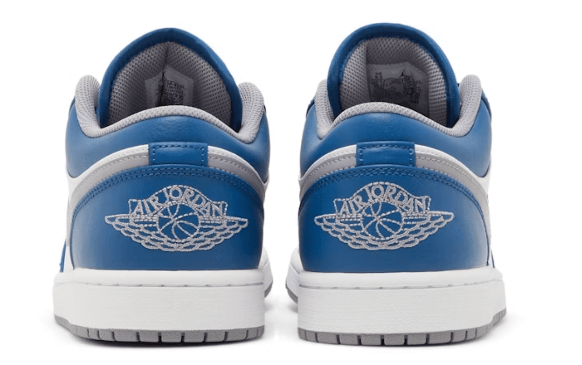 Jordan 1 Low True Blue (GS) sneakers, featuring gray and blue design with iconic Air Jordan logo on the back.